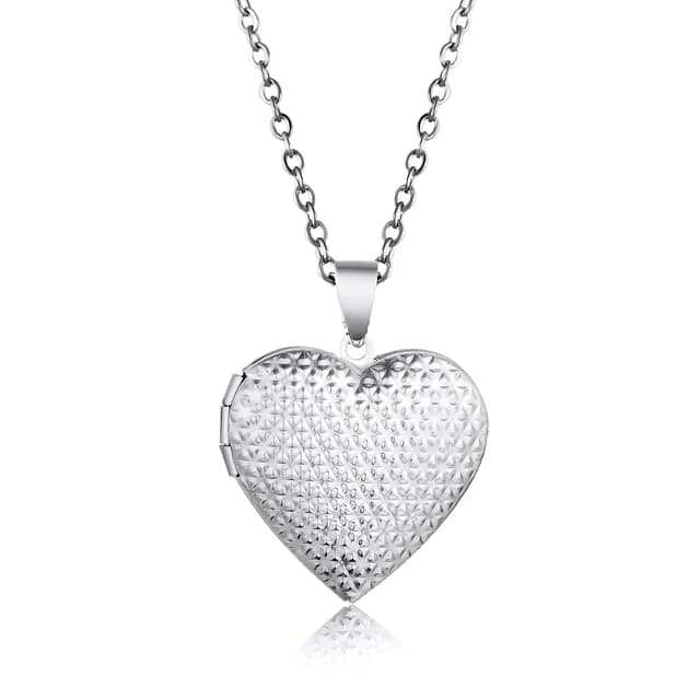A silver heart locket with a dotted lid.